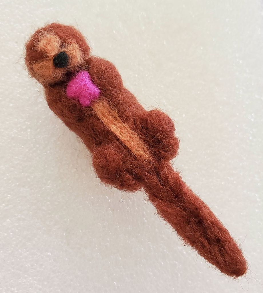 small felt otter holding a sea star